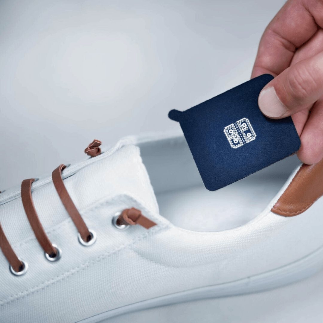 Hand legt das PowerInSoul Pad in einen weißen Sneaker